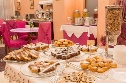 a table with many different types of pastries on it at Hotel San Giusto in Trieste