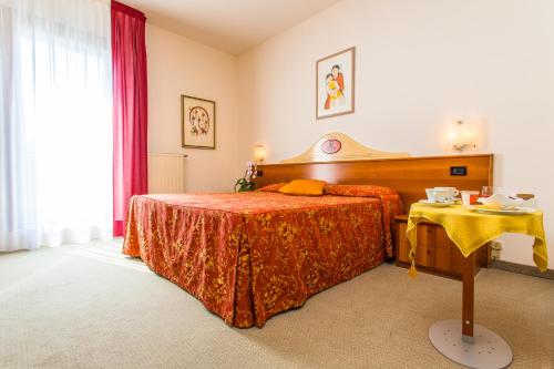 a bedroom with a bed and a table in it at Hotel Tegorzo in Fener