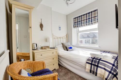 a bedroom with a bed and a dresser and a window at Sunrise Guest House in Bude