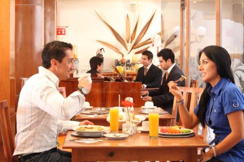 a group of people sitting at a table in a restaurant at Hotel Emily in Pachuca de Soto