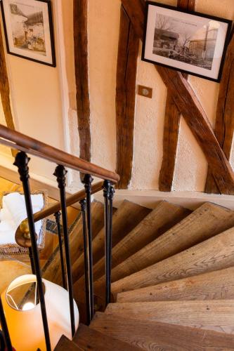 a staircase in a house with a wooden ceiling at Logis Hostellerie la Chaumière in Arsonval