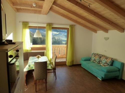 ein Wohnzimmer mit einem grünen Sofa und einem Tisch in der Unterkunft Polzhof in Kastelruth