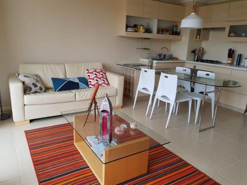 a living room with a couch and a table and chairs at Laguna Bahía, Algarrobo in Algarrobo