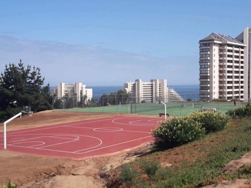 a basketball court in a city with tall buildings at Laguna Bahía, Algarrobo in Algarrobo