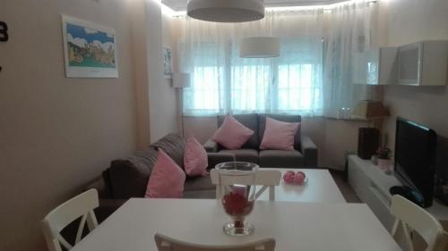 a living room with a table and a couch at Apartamentos Sueño Nevado con Piscina a pie de Telesilla in Sierra Nevada