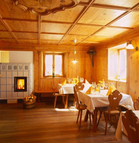 a dining room with two tables and a fireplace at Gasthof Weisses Kreuz in Naturno
