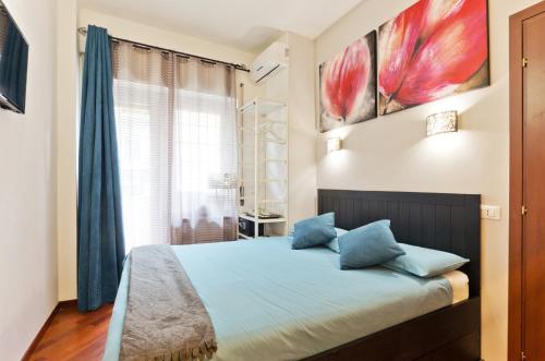ローマにあるVatican QG Roomsのベッドルーム1室(青い枕のベッド1台、窓付)