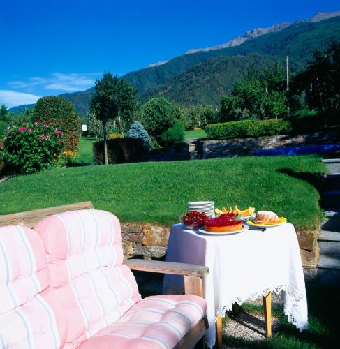 a table with a couch and a table with food on it at Gasthof Weisses Kreuz in Naturno