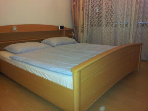 ウィーンにあるApartment City-Centerのベッドルーム1室(白いシーツと枕が備わる木製ベッド1台付)