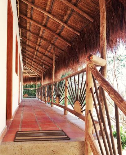 a porch of a building with a thatched roof at Hostal Nibuni Palomino in Palomino