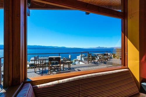 einen Blick aus dem Fenster eines Balkons mit Tischen und Stühlen in der Unterkunft Hostel Inn Bariloche in San Carlos de Bariloche