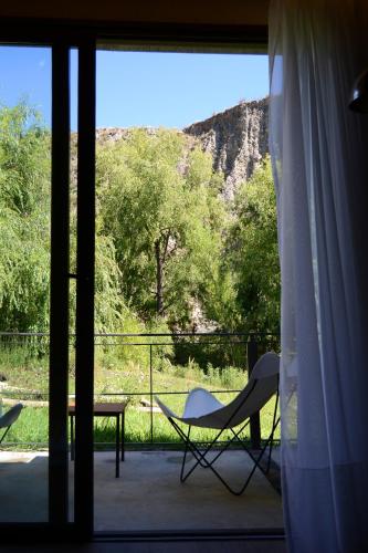 a room with a table and a chair on a balcony at Posada del Blanco in Potrerillos