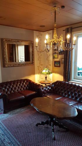 a living room with a leather couch and a table at Paul Lincke Residenz in Hahnenklee-Bockswiese
