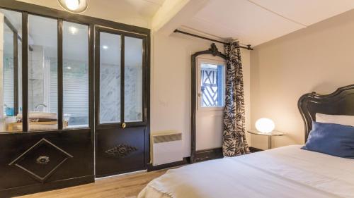 a bedroom with a bed and a window at Appartement Le Notre Dame in Honfleur