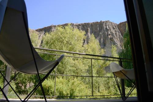 a balcony with two chairs and a view of a mountain at Posada del Blanco in Potrerillos