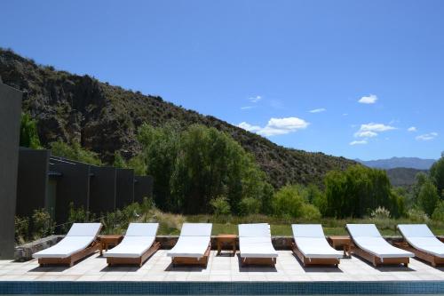 a group of lounge chairs sitting next to a swimming pool at Posada del Blanco in Potrerillos