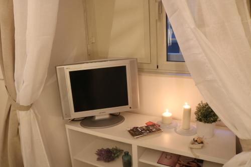 a computer monitor sitting on a table with candles at Casa Marinella in Naples