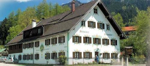a large white building with a brown roof at Gästehaus Enzianhof Hotel Garni in Oberammergau