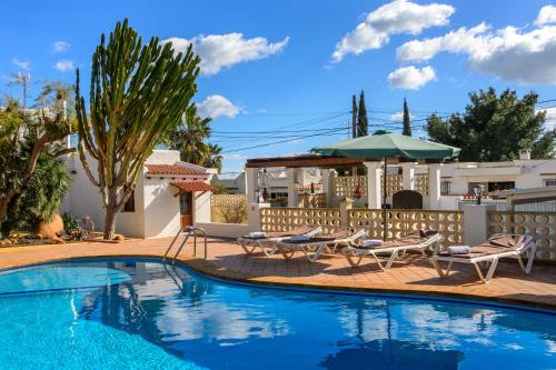 a swimming pool with two chairs and a umbrella at Villa Can Giovanni in Sant Jordi