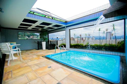 a swimming pool in a building with a large window at Rivieras Motel (Adult Only) in Santos