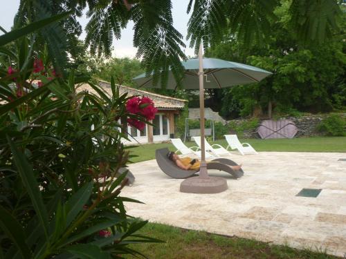 a person laying on a couch under an umbrella at Chateau de Mauras in Chomérac