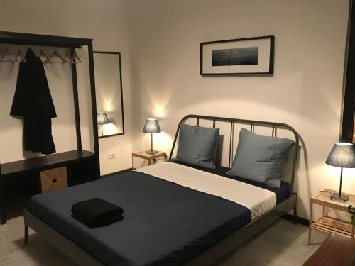 una camera con un letto bianco e nero e 2 lampade di Style And Room a Napoli