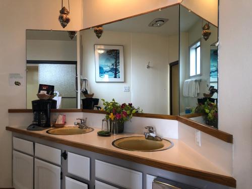 La salle de bains est pourvue de 2 lavabos et d'un grand miroir. dans l'établissement Webb's Scenic Surf, à Cannon Beach