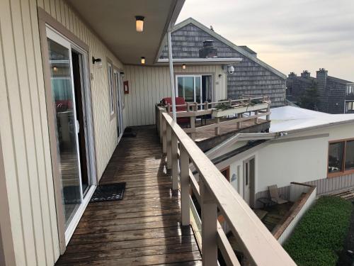 a balcony of a house with a wooden deck at Webb's Scenic Surf in Cannon Beach