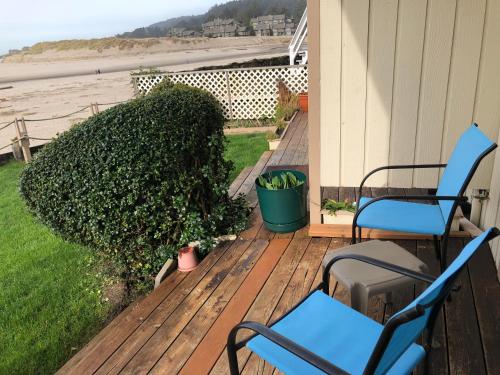 a deck with two chairs and a bush on a house at Webb's Scenic Surf in Cannon Beach