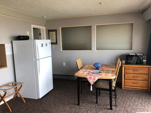 a kitchen with a table and a white refrigerator at Webb's Scenic Surf in Cannon Beach