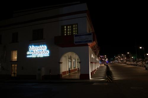 a sign on the side of a building at night at Mansion de los Abuelos in Atlacomulco de Fabela