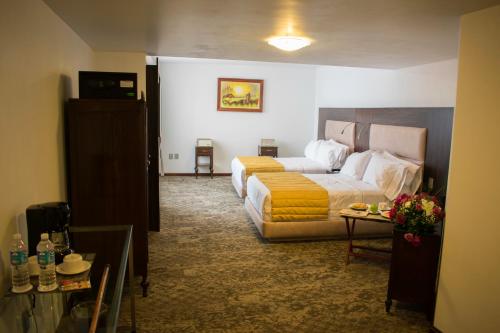 Atlacomulco de FabelaにあるMansion de los Abuelosのベッドとソファ付きのホテルルーム