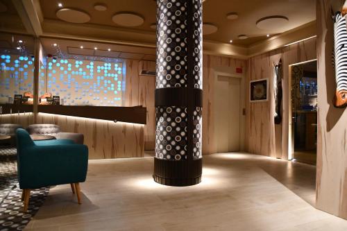 a lobby with a column and a blue chair at Hotel Oriente in Teruel