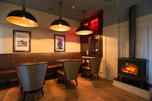 a restaurant with a fireplace and a table and chairs at Metro Apartments Dublin Airport in Dublin