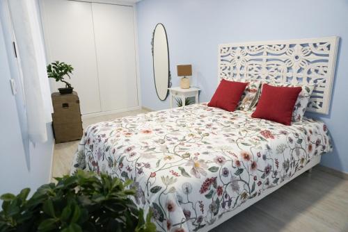 a white bedroom with a bed with red pillows at Ericeira Holiday House - Centre of the Village in Ericeira