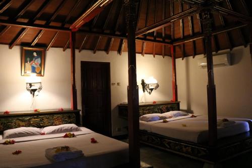 duas camas num quarto com em Puri Bunga Beach Cottages em Senggigi