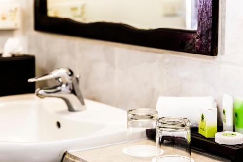 a bathroom counter with a sink and a mirror at Tambua Sands Beach Resort in Korotogo
