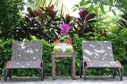 two chairs and a table with two chickens on it at Puri Bunga Beach Cottages in Senggigi 