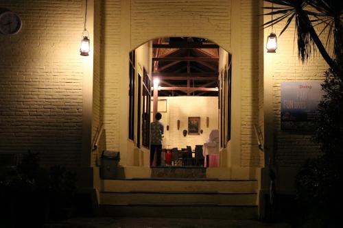 a person standing in the doorway of a building at night at Puri Bunga Beach Cottages in Senggigi 