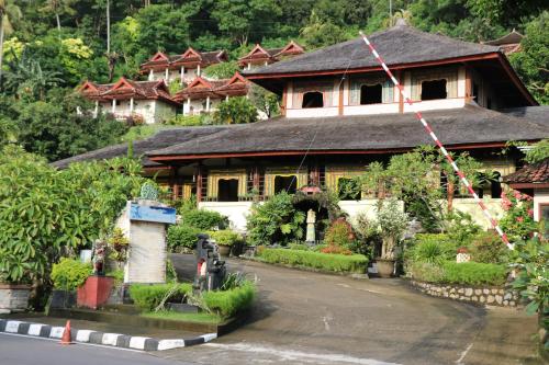 a large house with a roof on a street at Puri Bunga Beach Cottages in Senggigi 
