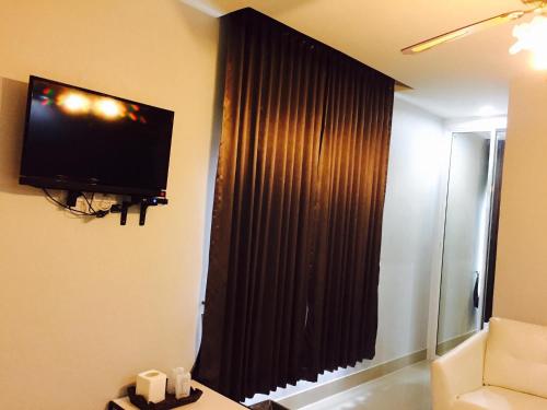 a living room with a large window with black curtains at Relax Resort in Nakhon Sawan