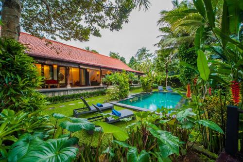 a villa with a swimming pool in a garden at Luxury 3BR Infinity Jungle View Aashaya Villa Ubud in Ubud
