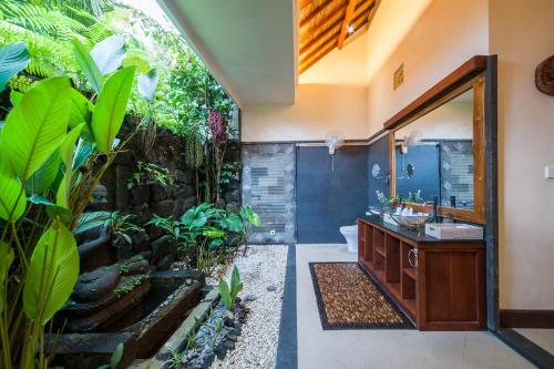 a bathroom with a sink and a large mirror at Luxury 3BR Infinity Jungle View Aashaya Villa Ubud in Ubud