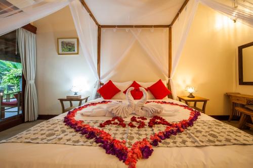 a bedroom with a bed with a heart made out of flowers at Luxury 3BR Infinity Jungle View Aashaya Villa Ubud in Ubud