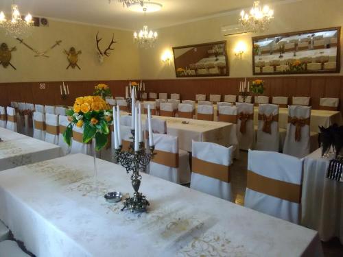 a dining room with white tables and white chairs at Zajazd Zagłoba in Widoma