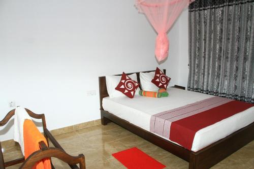 a bedroom with a bed and a chair and a window at Nethmi Homestay in Sigiriya