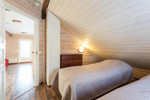 En eller flere senge i et værelse på Pyry ja Tuisku Cottages