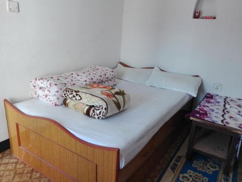a bed with two pillows on it in a room at kayastha restaurant & lodge in Bandīpur