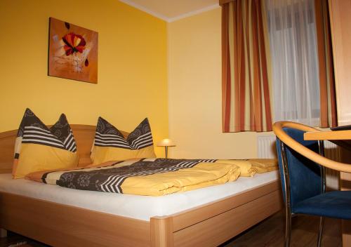 a bedroom with a bed with yellow walls at Frühstückspension Kuzmic in Wartberg