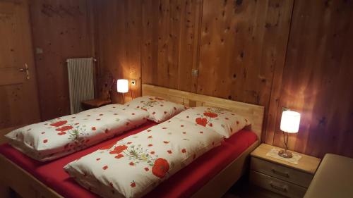 a bedroom with two beds with flowers on them at Lüch dl Chessl - Kesslhof in San Martino in Badia
